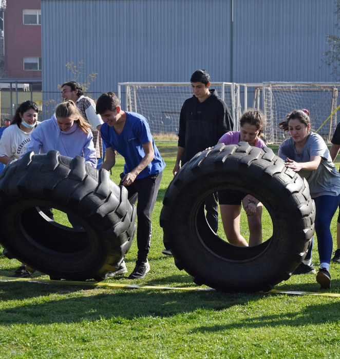 Estudiantes moviendo una rueda de tractor, en el marco de los Fit Games