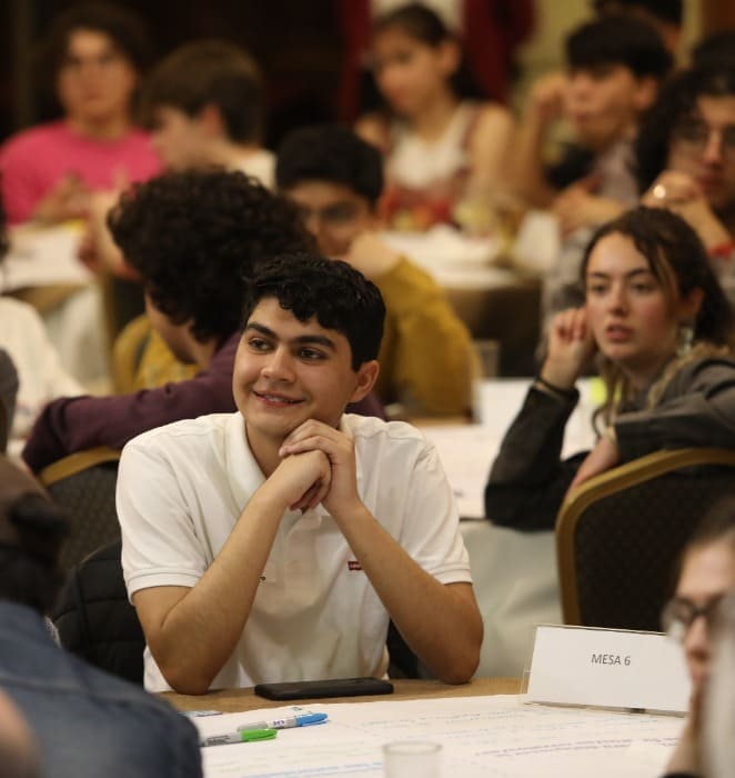 Grupo de estudiantes participa en jornada de diálogo al interior de auditorio del campus San Joaquín.