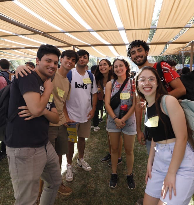 Grupo de estudiantes de la UC sonríen a la cámara durante actividad al aire libre en el campus San Joaquín.