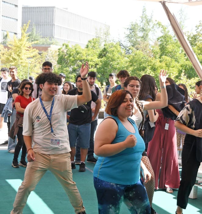 Grupo de personas participa de actividad deportiva al aire libre al interior del campus San Joaquín.