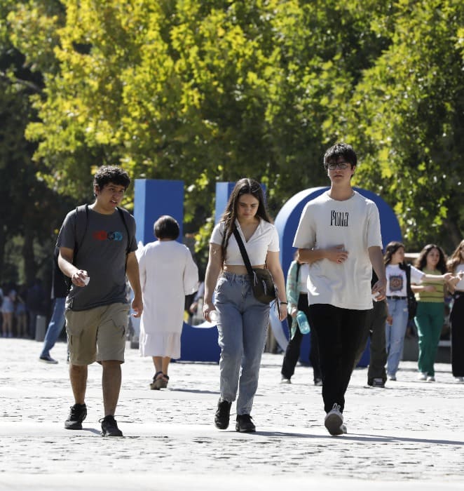 Estudiantes caminan al interior del campus San Joaquín de la PUC.