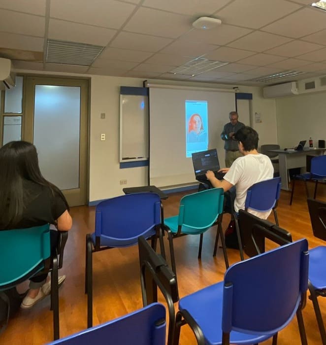 Profesor dicta taller de fotografía digital al interior de sala en campus San Joaquín.