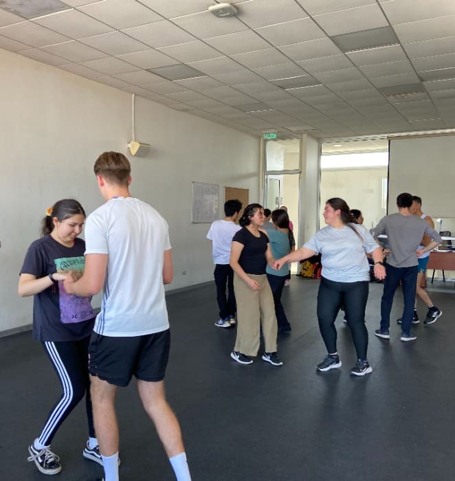 Estudiantes practican pasos de salsa como parte de su rutina de ensayo en el Taller de Salsa y Merengue Básico e Intermedio impartido en la PUC.