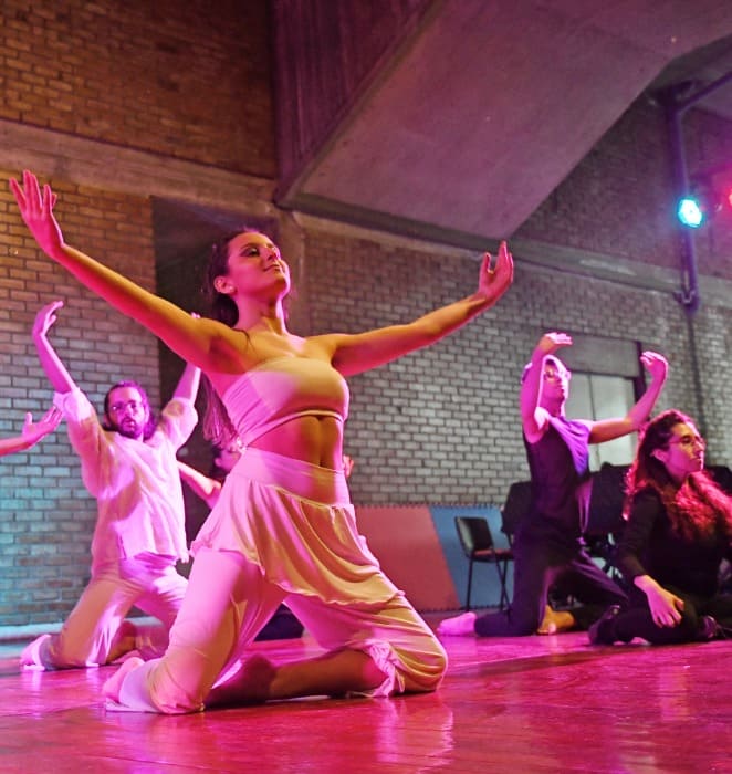 Grupo de estudiantes presenta rutina de danza en auditorio de la UC.