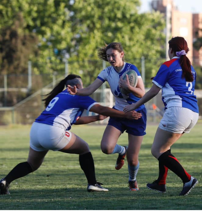 Tres alumnas jugando rugby en campus San Joaquín UC.