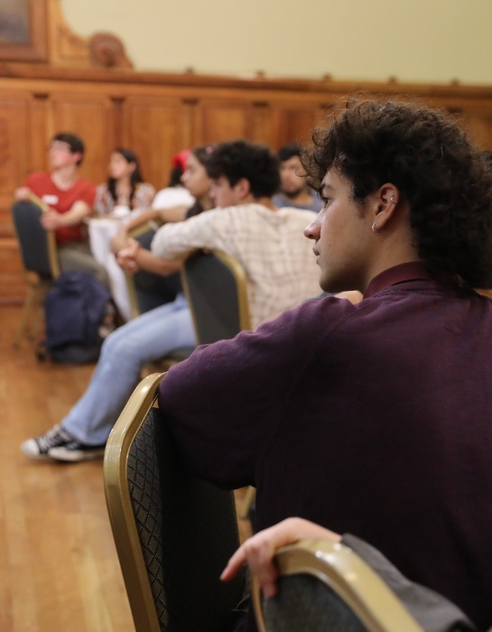 Grupo de estudiantes UC participa de encuentro de diálogo al interior de auditorio de Casa Central.