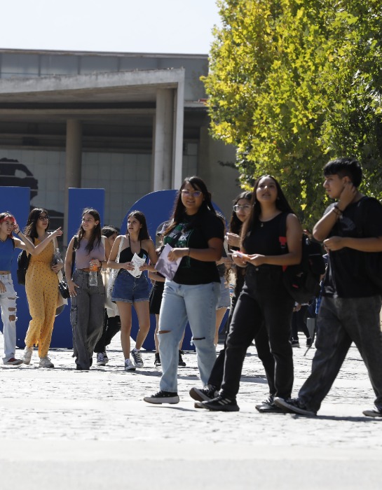 Grupo de estudiantes UC camina y conversa al interior del campus San Joaquín.