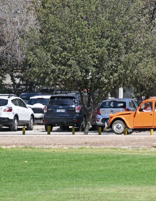 Imagen muestra una serie de vehículos estacionados al interior del campus San Joaquín de la PUC.