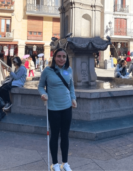 Estudiante UC de intercambio en España frente a una pileta de ese mismo país.