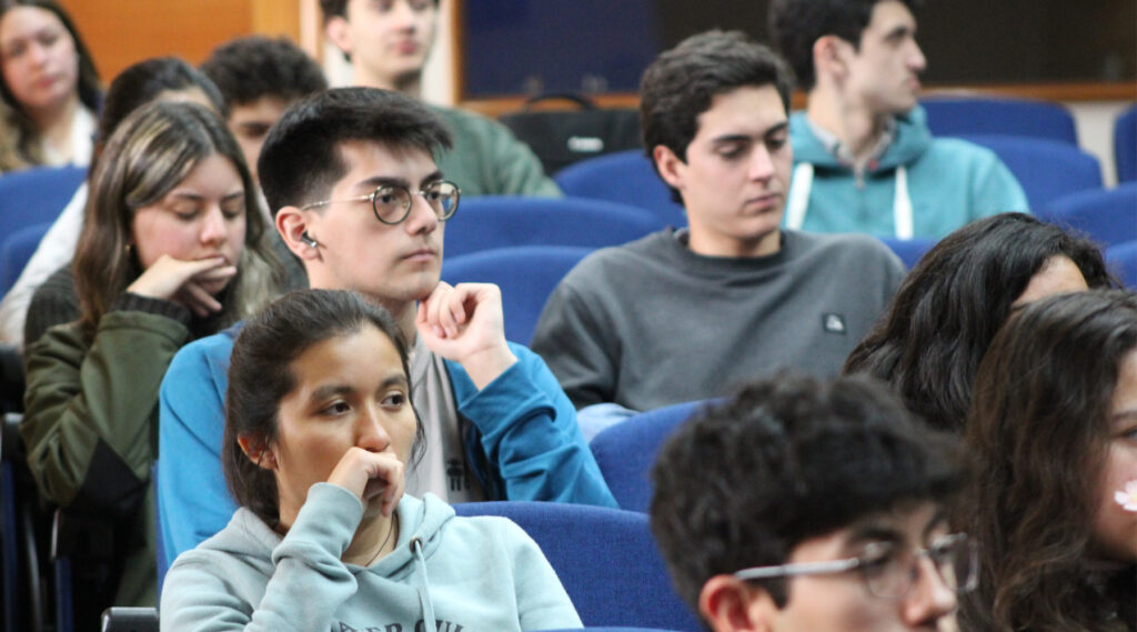 Estudiantes atentos escuchando los relatos y consejos del panel de Alumnis UC