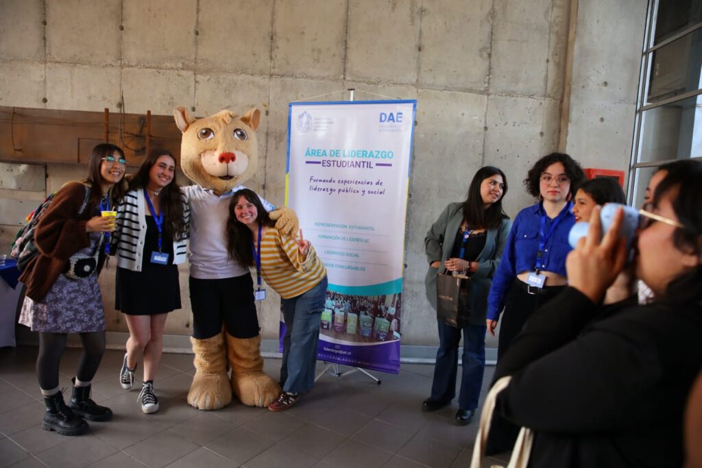 Pangui junto a tres estudiantes posando para una foto en el evento.