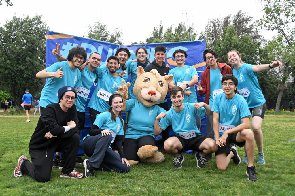 Estudiantes en Running UC junto a Pangui, mascota de la Universidad.